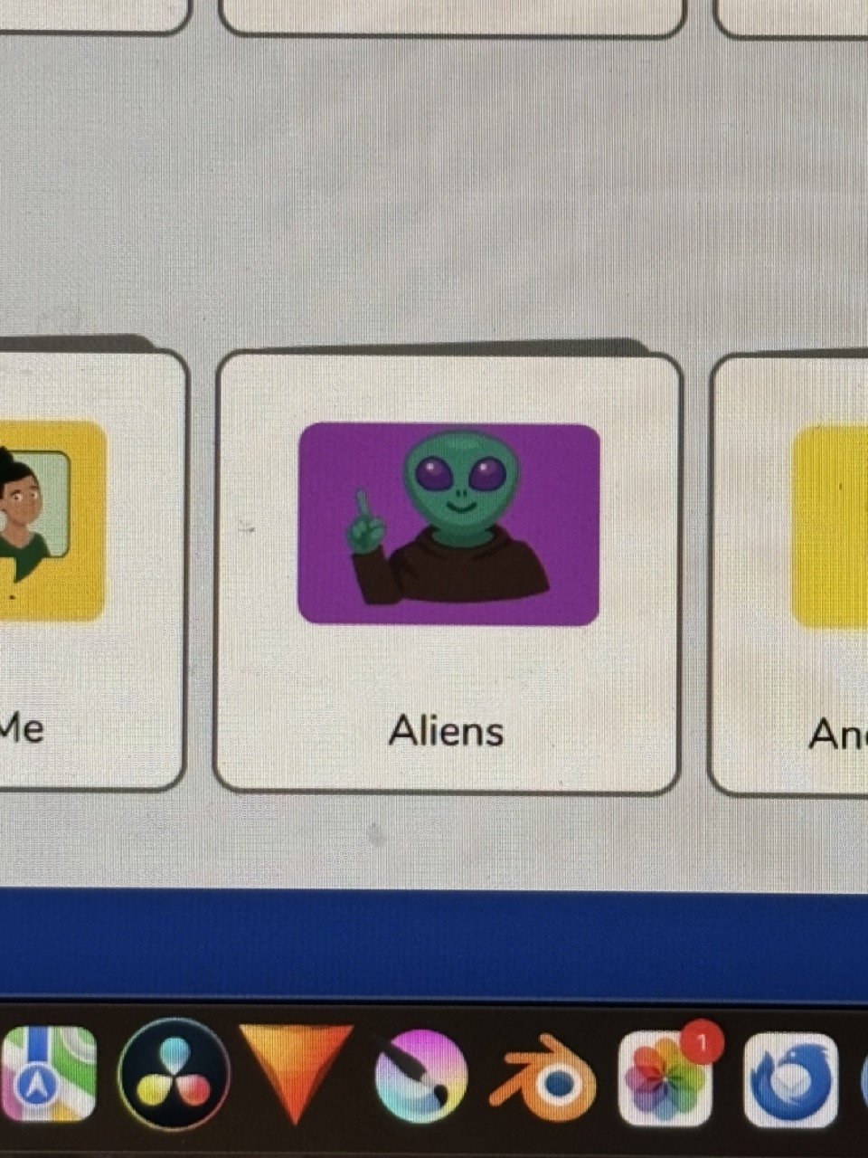 Photograph of a computer screen, part of the interface includes a stylised folder with a cartoon alien raising its hand, folder title: Aliens